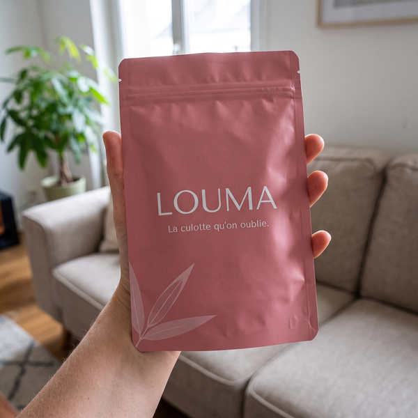 Pochette Louma tenue à la main dans un salon