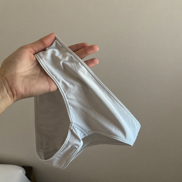 Culotte gris perle tenue à la main, matière visible