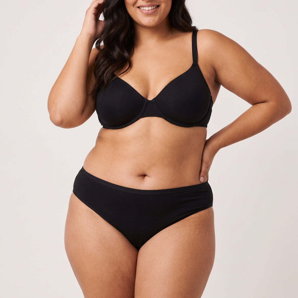 Femme portant la culotte bikini classique Louma noire, plan entier en studio