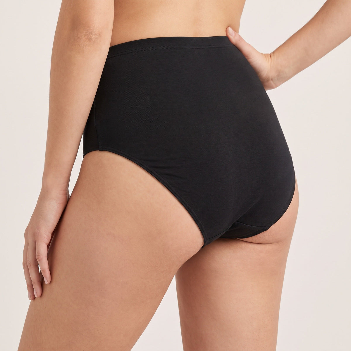 Culotte haute Louma noire portée, vue de trois-quarts arrière, hanche et taille