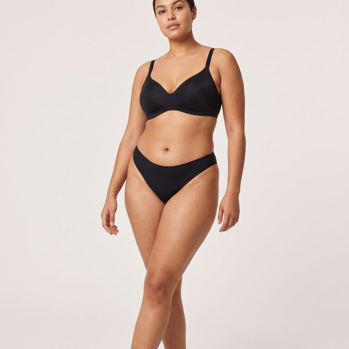 Femme portant la culotte échancrée Louma noire, plan entier en studio