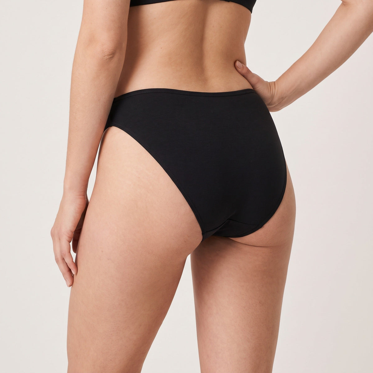 Culotte échancrée Louma noire portée, vue de trois-quarts arrière, hanche et taille