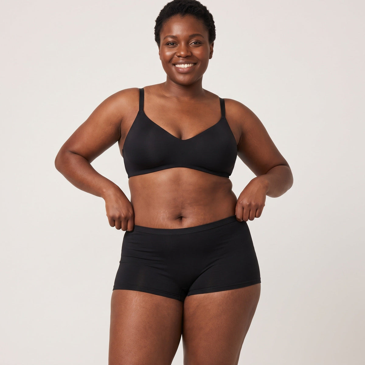 Femme portant le shorty Louma noir, plan entier en studio